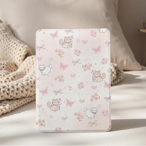 Può includere: Una custodia per tablet rosa chiaro con un motivo ripetuto di gatti dei cartoni animati, farfalle rosa, fiocchi e fiori. La custodia ha una combinazione di colori tenui e pastello, con un effetto sfumato. Il design generale è stravagante e femminile.