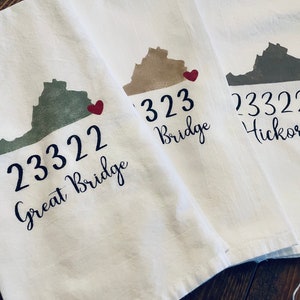 May include: Three white tea towels with a red heart and an outline of the state of Virginia. The towels are labelled with the text "23322 Great Bridge", "23323 Bridge", and "23322 Hickory".