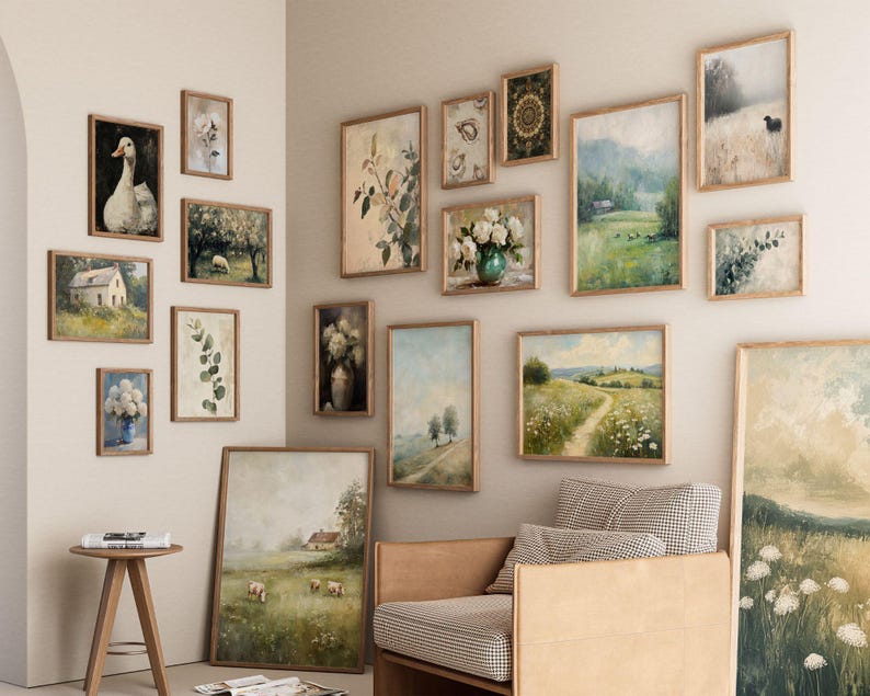 May include: A collection of framed landscape and floral art prints in various sizes and styles. The artwork features pastoral scenes, botanical illustrations, and a goose portrait, all in wooden frames, creating a gallery wall aesthetic.