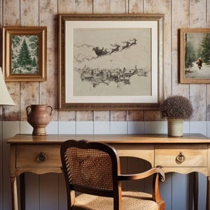 May include: A cozy interior scene featuring a wooden desk with a lamp, vase, and chair. Above the desk are three framed artworks: a Christmas tree print, a Santa sleigh scene, and a winter landscape. The wall has a wood paneling design.