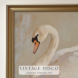 May include: A framed painting of a swan with a curved neck and white feathers. The swan has a black and orange beak and is set against a neutral background. The frame is gold. Text on the painting reads "VINTAGE DISCO" and "Curated Timeless Art."