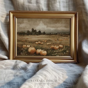 May include: A framed vintage painting depicts a pumpkin patch in a field under a cloudy sky. The artwork features pumpkins in various sizes and shades of orange, set against a backdrop of trees and a muted landscape. The frame is gold, and the text "VINTAGE DISCO Curated Timeless Art" is at the bottom.