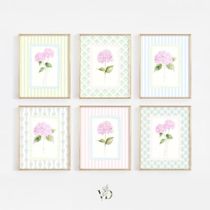 May include: A set of six rectangular wall art prints in gold frames, each featuring a watercolor illustration of pink hydrangea flowers centered on backgrounds with varied patterns including vertical stripes and geometric floral motifs.