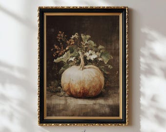 May include: A framed wall art print featuring a still life painting of a pale, round pumpkin surrounded by green leaves and small white flowers. The artwork is encased in a black frame with an inner gold trim, set against a dark, textured background.