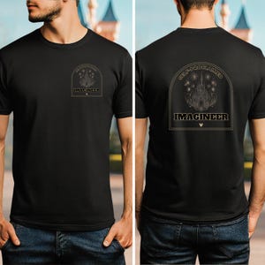 May include: A black t-shirt with a gold graphic of Cinderella's castle and fireworks. The text "Self-Proclaimed Imagineer" is printed on the back of the shirt.