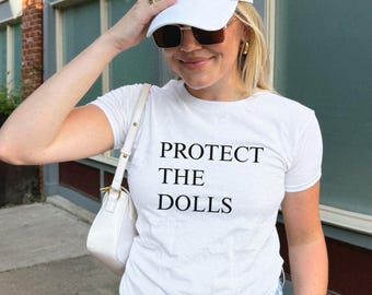 Protect The Dolls Baby Tee, Gender Equality Baby Tee, LGBTQ Pride Baby Tee, Feminist Activist Shirt, Trans Rights Gift, Human Rights Tee