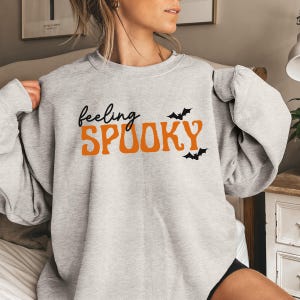 This image features the Feeling Spooky design for the athletic heather sweatshirt.