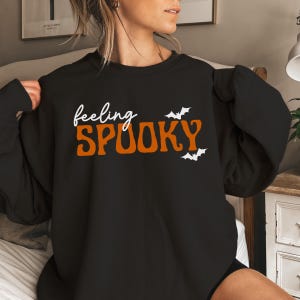 This image features the Feeling Spooky design for the black sweatshirt.