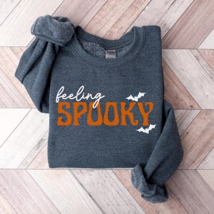 This image features the Feeling Spooky design for the heather dark gray sweatshirt.