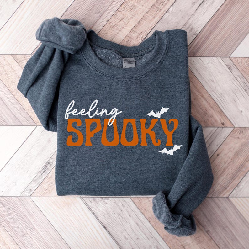 This image features the Feeling Spooky design for the heather dark gray sweatshirt.