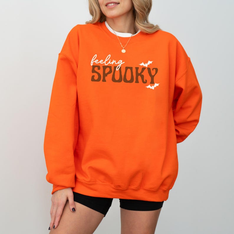 This image features the Feeling Spooky design for the orange sweatshirt.