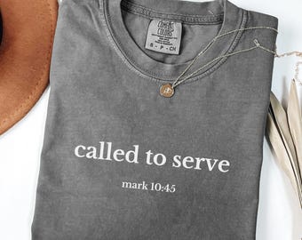 May include: Gray t-shirt with the text "called to serve" and "mark 10:45" printed in white.