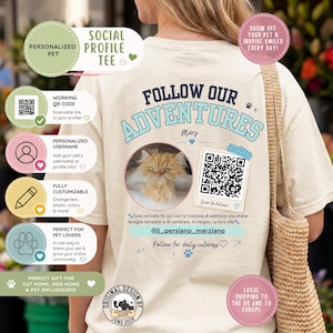 Può includere: Una t-shirt color crema con una grafica sul retro che riporta il testo FOLLOW OUR ADVENTURES, una foto circolare di un gatto arancione soffice, un codice QR scansionabile e l'handle @il_persiano_marziano con testo in italiano sottostante.