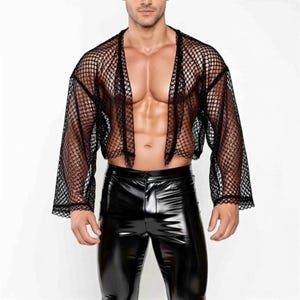 May include: Black mesh long-sleeve top with a cropped design. The top has a wide, open neckline and is made of a large-holed mesh fabric. The model is also wearing black, shiny, faux leather pants.