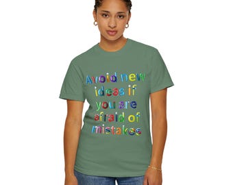 May include: A green t-shirt with the text "Avoid new ideas if you are afraid of mistakes" in colourful letters.
