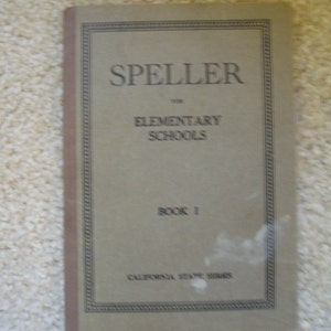 May include: A vintage book titled "Speller for Elementary Schools, Book 1, California State Series". The cover is beige with black text and a decorative border.