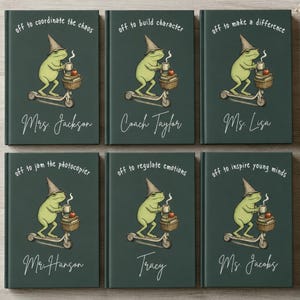 May include: Six dark green notebooks featuring a frog wearing a pointed hat, riding a scooter, and holding a mug. Each cover displays unique text: off to coordinate the chaos, build character, make a difference, jam the photocopier, regulate emotions, or inspire young minds, with personalized names below.