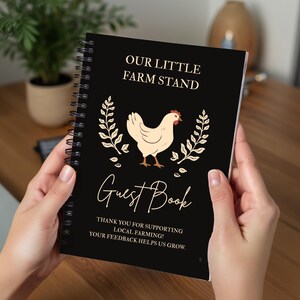 May include: A black spiral-bound notebook titled Our Little Farm Stand Guest Book. The cover features a cream-colored chicken illustration flanked by two leafy branches, with the text: Thank you for supporting local farming! Your feedback helps us grow.