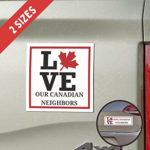 May include: White square car magnet with a red maple leaf and the words "LOVE OUR CANADIAN NEIGHBORS" in black text. The magnet is on a silver car.