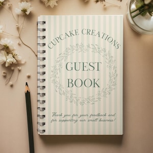 May include: A spiral-bound guest book with a light green and white striped cover. The cover features the text "CUPCAKE CREATIONS GUEST BOOK" in a circular design and a floral wreath. The bottom of the cover reads "Thank you for your feedback and for supporting our small business!"