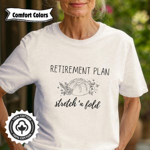 Puede incluir: Camiseta blanca con una ilustración en blanco y negro de una hogaza de pan y el texto "Retirement Plan stretch 'n fold".