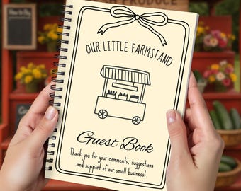 May include: A spiral-bound guest book with a cream-colored cover is held in front of a red produce stand. The cover features a black line drawing of a farm stand, a bow, and the words "OUR LITTLE FARMSTAND" and "Guest Book". The text reads "Thank you for your comments, suggestions and support of our small business!"