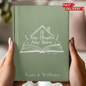 May include: A sage green journal with the words "New Chapter New Home" and the names "Kate & William" printed on the cover. The design includes a house, an open book, and the year "est. 2026".