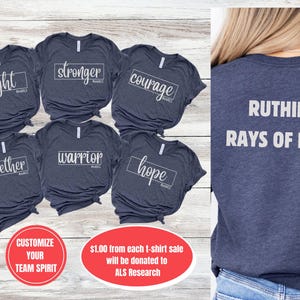 May include: Six navy blue t-shirts with white text. The shirts feature the words "fight", "stronger", "courage", "together", "warrior", and "hope". A navy blue t-shirt with the text "RUTHIE'S RAYS OF HOPE" is shown on a person. The text "$1.00 from each t-shirt sale will be donated to ALS Research" is also shown.