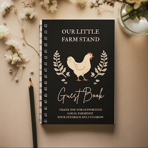May include: A black spiral-bound guest book with the text "OUR LITTLE FARM STAND" and "Guest Book". The cover features a cream-colored hen illustration with floral accents. The text "THANK YOU FOR SUPPORTING LOCAL FARMING!! YOUR FEEDBACK HELPS US GROW." is also visible.
