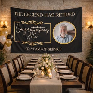 May include: A black banner with gold text and accents that reads "THE LEGEND HAS RETIRED" and "Congratulations John". A photo of a smiling man is in a gold circle. The banner also says "42 YEARS OF SERVICE". A table is set for a celebration.