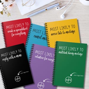 May include: A collection of spiral-bound notebooks in various colors, each with a different humorous phrase in white text. The notebooks are red, black, blue, yellow, purple, and green. The phrases include "create a spreadsheet," "reply with a meme," and "arrive late to meetings."