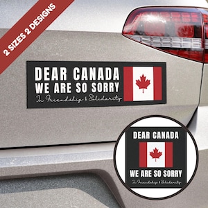 May include: A black and white car magnet with the text "Dear Canada We Are So Sorry In Friendship & Solidarity" and a Canadian flag.
