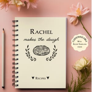 May include: A cream-colored spiral bound notebook with the text "RACHEL makes the dough" and a drawing of a loaf of bread. The notebook has a customizable label with the text "CUSTOMIZABLE with RECIPE TEMPLATES INSIDE".