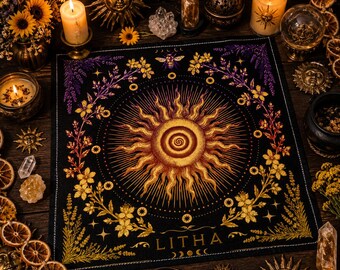 May include: A black square altar cloth with a central sun design in shades of gold and orange, surrounded by floral and celestial motifs. The word "LITHA" is printed at the bottom. The cloth is part of a spiritual or Wiccan theme.