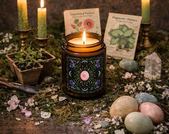May include: A lit candle in a glass jar with a decorative label featuring a pink spiral design, surrounded by purple flowers and crescent moons. The scene includes lit candles, seed packets, and decorative stones, creating a mystical ambiance.