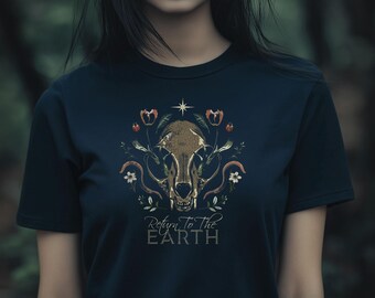 May include: Navy blue t-shirt featuring a gold-colored skull design with floral accents and the text "Return To The Earth". The design includes a star and various botanical elements. The shirt is a dark color.