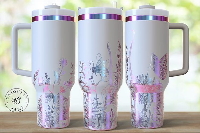 May include: White travel mug with a handle, featuring a floral and insect design in pink, purple, and silver. The mug has a silver rim with a pink and purple iridescent band. The bottom of the mug has a floral design. The mug has the words "Uniquely Sami" on it.