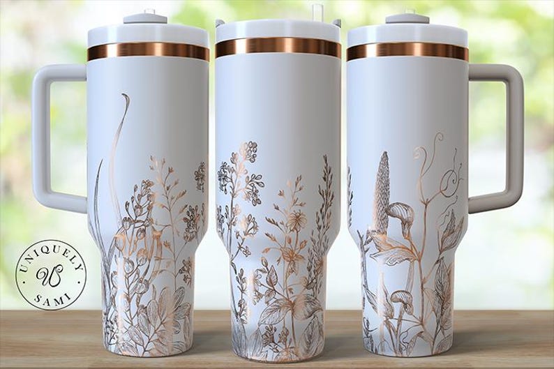 May include: Three white travel mugs with copper-colored accents and handles. Each mug features a floral design in shades of copper and brown. The mugs have a lid and a handle. The logo "Uniquely Sami" is visible on the left mug.