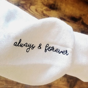 May include: White sweatshirt with the text "always & forever" embroidered in black.