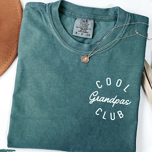 Peut inclure: Un t-shirt bleu sarcelle avec le texte "Cool Grandpas Club" en lettres blanches. Le t-shirt est fait d'un matériau doux et confortable et est parfait pour tous les jours.