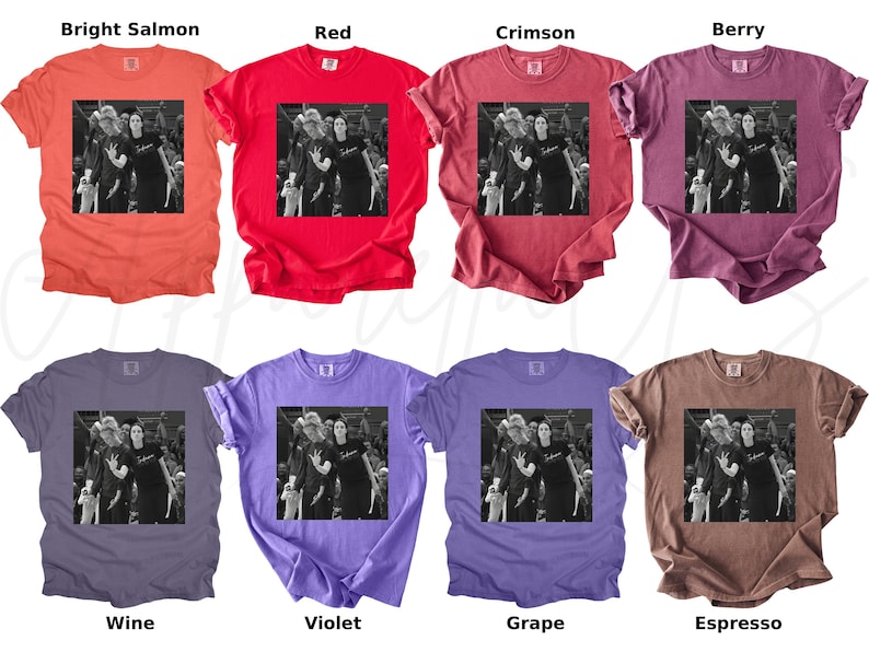 May include: A collection of eight different colored t-shirts. Each shirt features a black and white image of people. The shirts are in various colors, including bright salmon, red, crimson, berry, wine, violet, grape, and espresso.