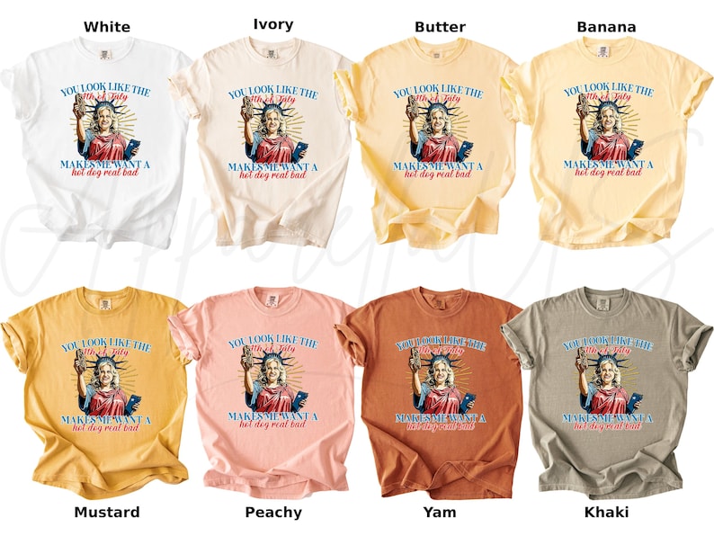 Puede incluir: Una colecci&oacute;n de camisetas en varios colores, incluyendo blanco, marfil, mantequilla, pl&aacute;tano, mostaza, melocot&oacute;n, &ntilde;ame y caqui. Cada camiseta presenta un gr&aacute;fico de la Estatua de la Libertad con el texto: "You look like the 4th of July makes me want a hot dog real bad."