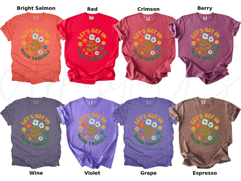 Peut inclure: Huit t-shirts de couleurs vari&eacute;es, dont saumon vif, rouge, cramoisi, baie, vin, violet, raisin et expresso. Chaque t-shirt affiche le texte "LET'S GET IN GOOD TROUBLE" avec un motif floral.