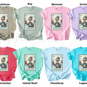 May include: Eight t-shirts in various colors, including Sandstone, Bay, Blossom, Orchid, Watermelon, Island Reef, Chambray, and Lagoon. Each shirt features a graphic of a skeleton with ballet shoes and a coffee cup, with the text "THE DANCE MOM".