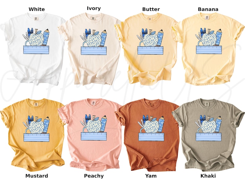 May include: Ten different colored t-shirts with a graphic of a blue apple with pencils and a ruler. The colors are white, ivory, butter, banana, mustard, peachy, yam, khaki, and black.