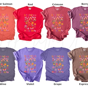Pode incluir: Uma cole&ccedil;&atilde;o de oito camisetas coloridas, cada uma com a frase "let kindness bloom" e gr&aacute;ficos florais e de borboletas. As camisetas est&atilde;o dispon&iacute;veis em v&aacute;rias tonalidades, incluindo salm&atilde;o brilhante, vermelho, carmesim, berry, vinho, violeta, uva e espresso.