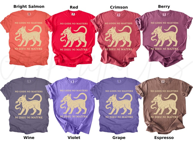 May include: A collection of eight t-shirts in various colors, including bright salmon, red, crimson, berry, wine, violet, grape, and espresso. Each shirt features a beige cat graphic with the text "NO GODS NO MASTERS" and "NI DIEU NI MAITRE".