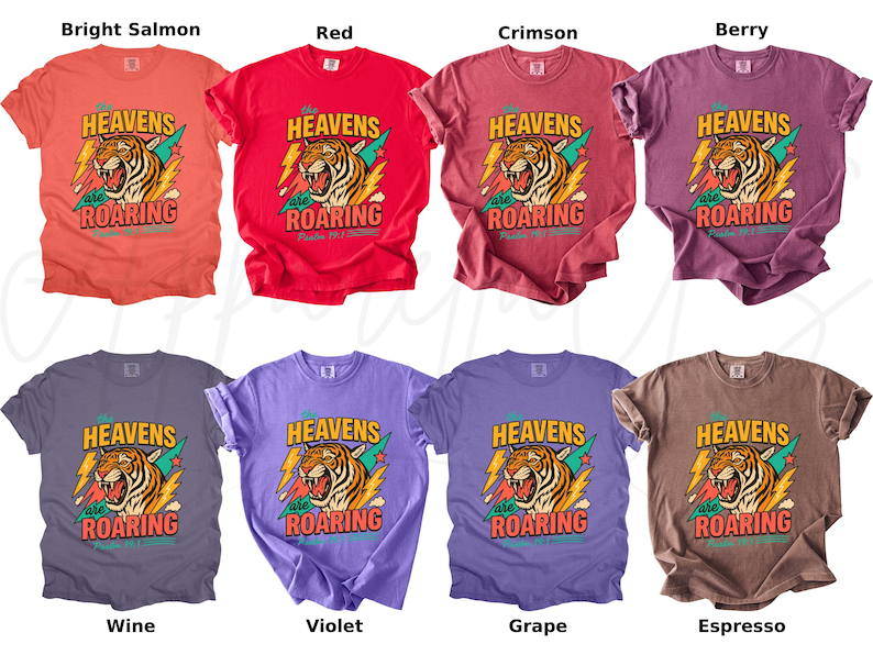 May include: A collection of eight t-shirts in various colors, including bright salmon, red, crimson, berry, wine, violet, grape, and espresso. Each shirt features a graphic of a roaring tiger with the text "HEAVENS are ROARING".