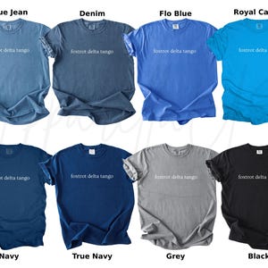 Op de afbeelding: Een collectie van acht crewneck t-shirts in verschillende kleuren, waaronder blauw, marine, grijs en zwart. Elk shirt heeft de tekst "foxtrot delta tango" op de voorkant gedrukt. De shirts worden gepresenteerd met hun kleurnamen: Blue Jean, Denim, Flo Blue, Royal Caribe, Navy, True Navy, Grey en Black.