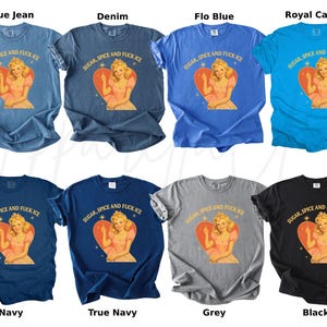 Peut inclure: Plusieurs t-shirts de couleurs vari&eacute;es, dont bleu, gris et noir. Chaque t-shirt pr&eacute;sente un motif d'une femme dans un c&oelig;ur avec le texte "SUGAR, SPICE AND FUCK ICE".